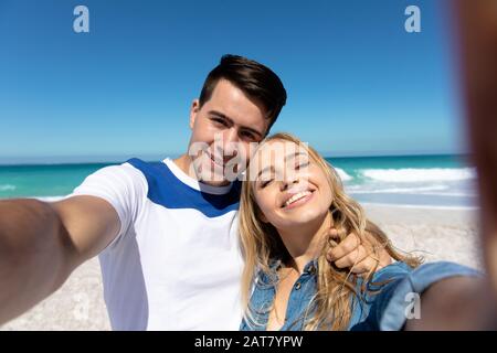 Young couple taking selfies at the beach Stock Photo