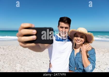 Young couple taking selfies at the beach Stock Photo