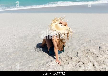 Young woman sitting on the sand Stock Photo