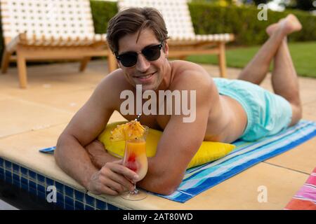 Young man relaxing near swimming pool on a sunny day Stock Photo