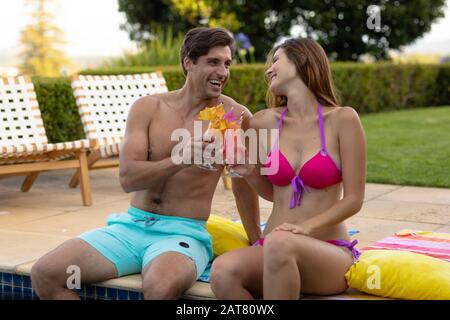 Happy young couple relaxing near the swimming pool Stock Photo