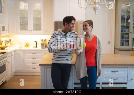 Happy young couple standing in the kitchen Stock Photo