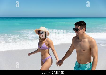 Young couple holding hands at the beach Stock Photo