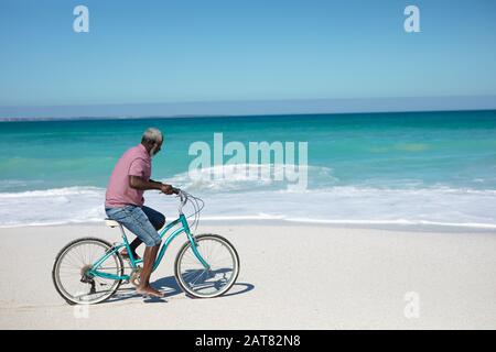 Old man with a bike at the beach Stock Photo