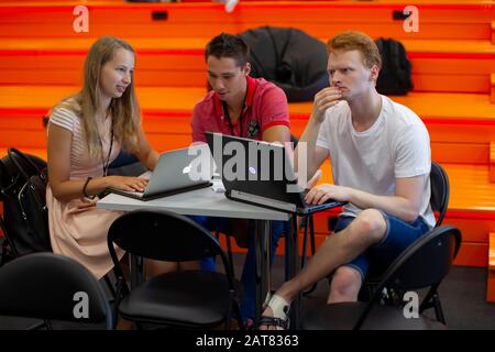 Belarus, Minsk city, August 06, 2017. Programmers Office. IT people ponder the project. A group of programmers at a table with computers. Stock Photo