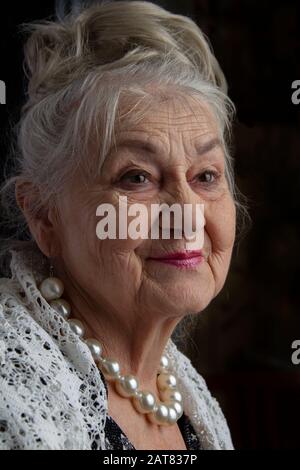 Portrait of a ninety year old woman. Beautiful old lady. Luxurious grandmother on a black background. Elderly beauty. The gray-haired well-groomed pen Stock Photo