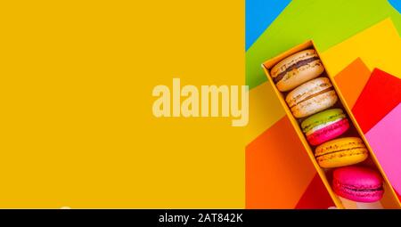 Colourful macaroon biscuits in box, still life, colorful background . Flat lay style. Stock Photo