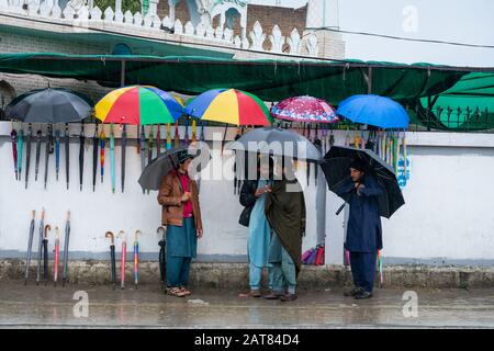 January 29, 2020 - KPK, Pakistan: Local residents purchasing umbrella from a street umbrella seller during rainy weather Stock Photo