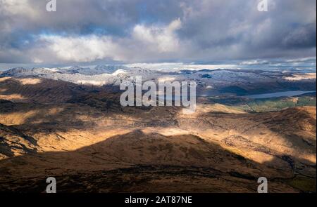 Dramatic winter view from the top of Ben Lomond towards Loch Lomond and the peaks of Arrochar Alps in Scottish Highlands. Stock Photo