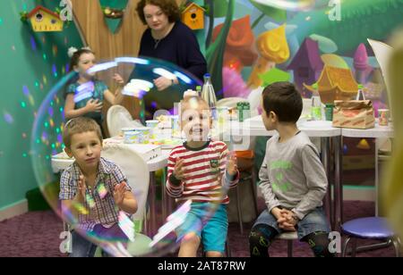 Soap bubbles show. Children's party. To burst the soap bubble Stock Photo