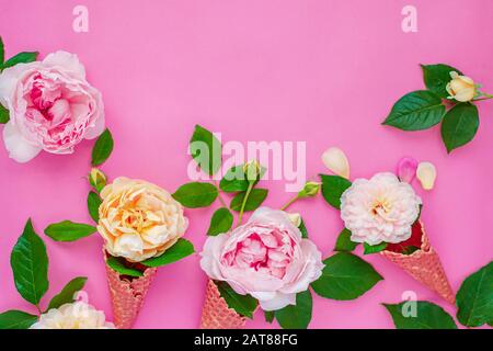 Ice cream from peony flowers in a waffle cone on a pink background from above, beautiful floral arrangement, vintage color, flat lay. Floral frame wit Stock Photo