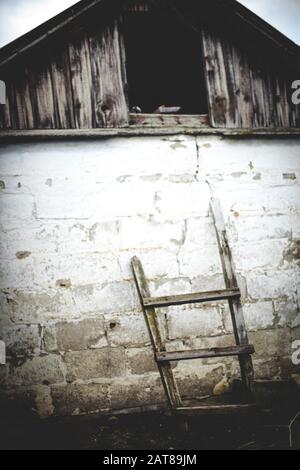 Old wooden staircase near bar wall in a rural yard. Stock Photo