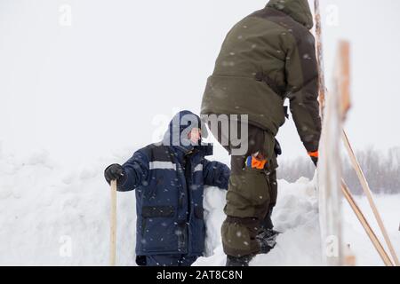 Two workers in overalls at a construction site Stock Photo
