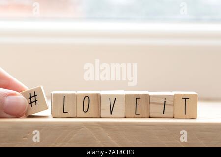 Wooden cubes with a hashtag and the words love it, social media concept background Stock Photo