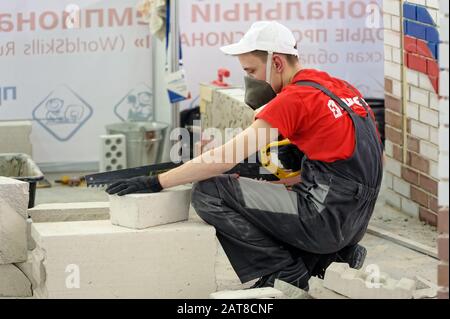 Young bricklayer performs a task of competition Stock Photo