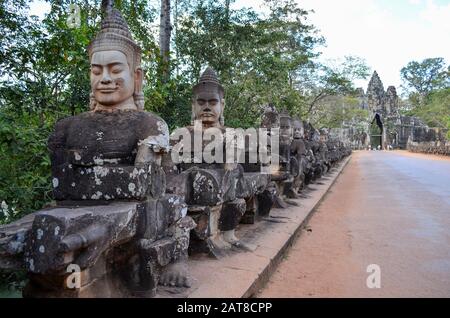 Ankor Wat, a 12th century historic Khmer temple and UNESCO world heritage site. Busts and statues of deities and guardian figures along a path to a st Stock Photo