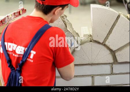 Young bricklayer performs a task of competition Stock Photo