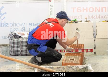 Young bricklayer performs a task of competition Stock Photo