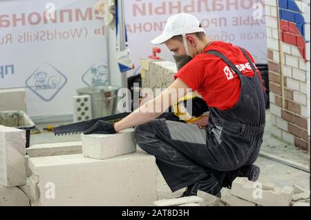 Young bricklayer performs a task of competition Stock Photo