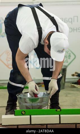 Young bricklayer performs a task of competition Stock Photo