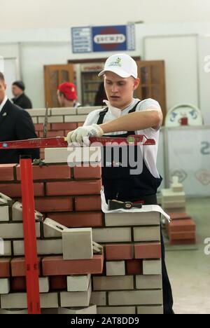 Young bricklayer performs a task of competition Stock Photo