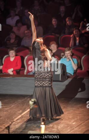 Beautiful female singer singing a song on stage Stock Photo