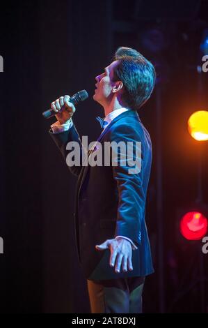 Beautiful man singing a song on stage Stock Photo