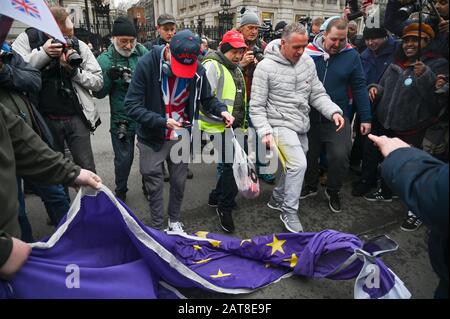 London UK 31st January 2020 - Brexit supporters kick an EU flag outside Downing Street in Whitehall London as Britain prepares to leave the EU at 11pm later this evening 47 years after joining : Credit Simon Dack / Alamy Live News Stock Photo