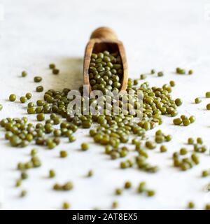 Dried mung beans with a spoon on a white table close up Stock Photo