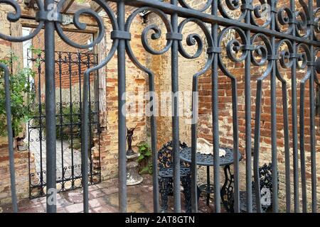 a view through wrought iron gate garden path entrance to a sanctuary Stock Photo