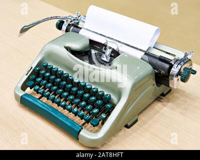Green retro typewriter on wooden table Stock Photo