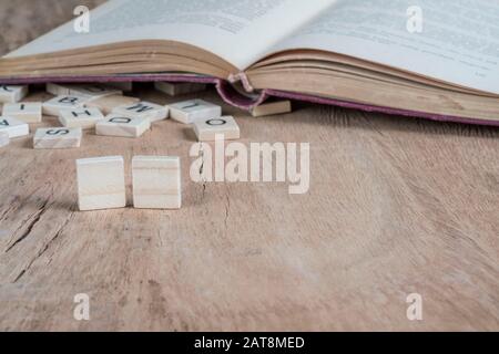 two blank cubes on a wooden table against old book Stock Photo
