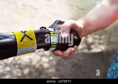 Handshake of African and European or American men. The concept of friendship and business relations between countries and continents. Stock Photo