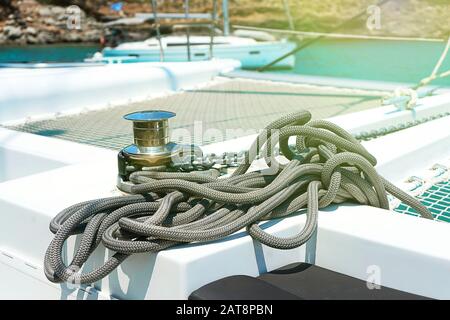 Yacht winch and cable on a sailing yacht. Rope wound on the small windlass of the yacht ship. Greece holiday. Stock Photo