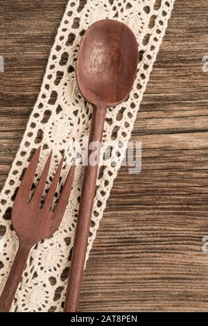 carved spoon and fork on a wooden background with copy space