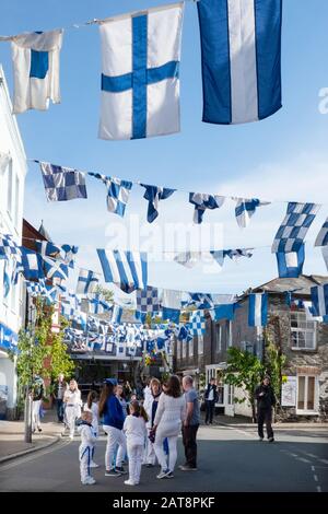 Traditional blue and white flags hanging in street during the Obby Oss celebrations, Padstow, Cornwall, UK Stock Photo