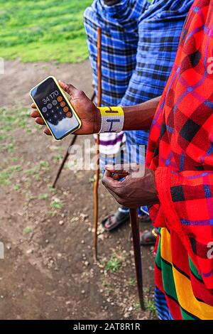 African man in traditional dress holding a cellphone. Tanzania, Africa. Close up. Stock Photo