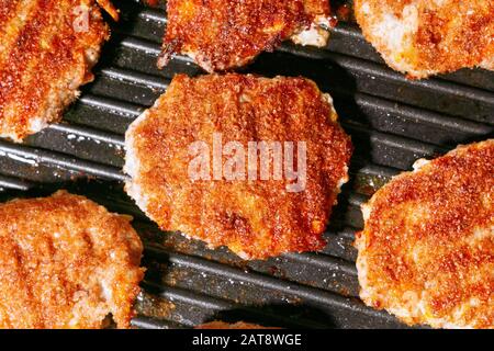 Close up of juicy beef burger patties grilling on a griddle pan Stock Photo