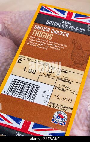 Plastic film wrapped ASDA chicken thighs with Union Jack graphic. British farm produce concept, food label close up, Use By date label, food packaging Stock Photo