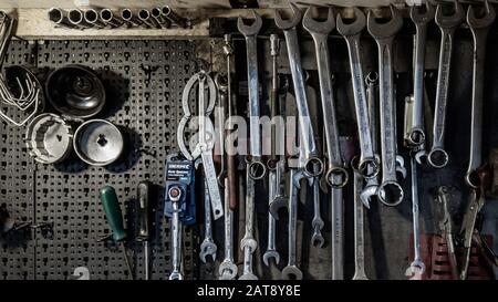 London, England - November 13 2019: Set of spanners, wrenches and screwdrivers on the wall of a car mechanic garage Stock Photo