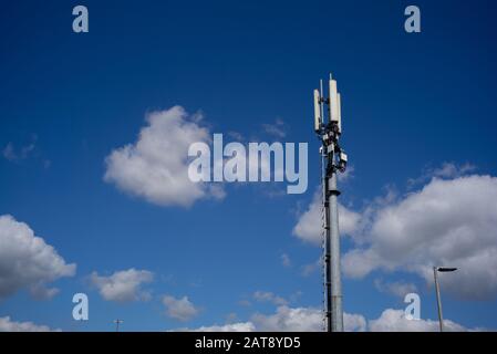 A mast of a communication phone and internet tower against a blue sky and clouds with copy space. Stock Photo