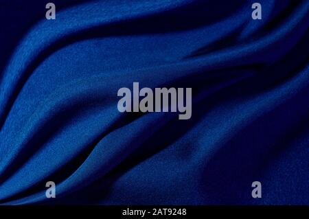 abstract fabric background. waves folds of fabric dark blue color trend 2020. design for any purpose Stock Photo