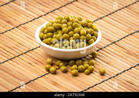 Canned green peas in the bowl on wood background Stock Photo