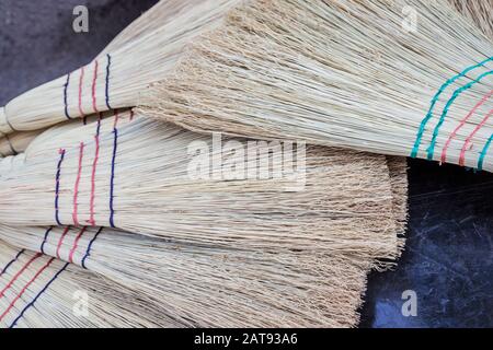 closeup pile of vintage straw brooms Stock Photo