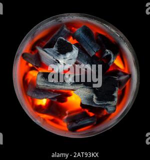 Burning coals. Decaying charcoal. Texture embers close up. Glowing embers smoldering. Fire place with glowing coal. Live coal burning. Background. Stock Photo