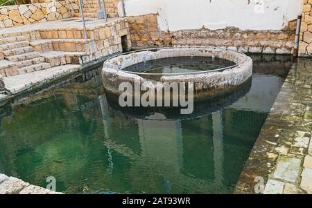 the ancient concrete bathing pool and limestone enclosure at ein mabua ein alfawar in the Prat stream in the west bank of israel and palestine Stock Photo