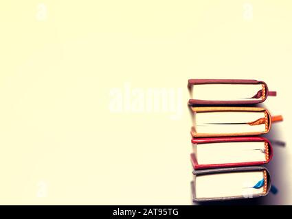 four small multi-colored books on a bright white background Stock Photo