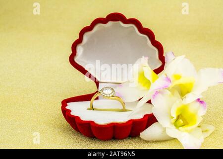 gold ring in red box on gold background Stock Photo