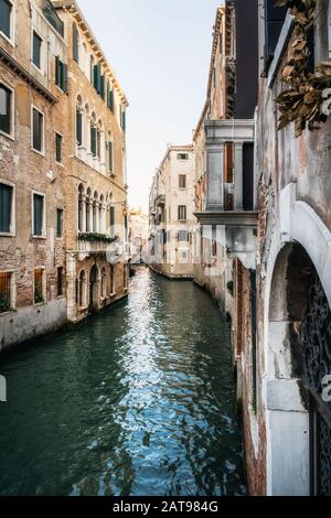 Colorful houses along narrow canal waters of Venice Italy Stock Photo