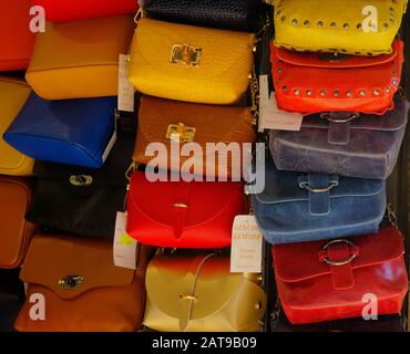 San Marino - October 19, 2019: Colorful leather handbags for sale hanging on wall of shop. Stock Photo